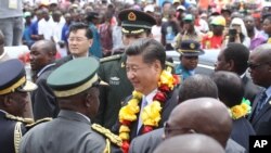 Chinese President Xi Jinping, centre, is welcomed upon his arrival in Harare, Zimbabwe, Tuesday, Dec. 1.2015.