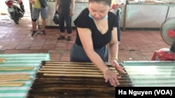 A woman works making candy in Ben Tre, Vietnam, where some say workplaces should embrace traits traditionally seen as feminine, such as humility.