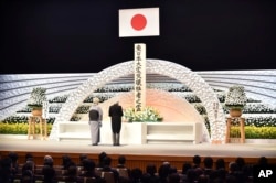 Japanese Emperor Akihito, right, along with Empress Michiko, delivers a speech in front of an altar for the victims of the March 11, 2011 earthquake and tsunami at the national memorial service in Tokyo Friday, March 11, 2016.