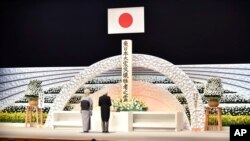 kaisar Jepang Akihito (kanan) bersama permaisuri Michiko, memberikan pidato di depan altar untuk menghormati para korban dalam peringatan 5 tahun bencana gempa bumi dan tsunami 11 Maret 2011 di Tokyo (11/3). 