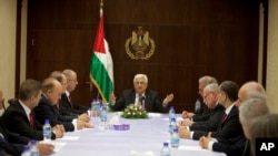 Palestinian President Mahmoud Abbas (C) meets with ministers of the unity government, in the West Bank city of Ramallah June 2, 2014. Abbas swore in a Palestinian unity government on Monday under a reconciliation deal with Hamas.
