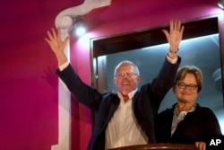 FILE - Presidential candidate Pedro Pablo Kuczynski greets supporters from the balcony of his party's headquarters next to his wife Nancy Lange in Lima, Peru, June 5, 2016.