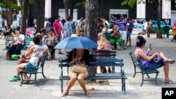 FILE - People surf the Internet at a Wi-Fi hotspot in Havana, Cuba, Nov. 25, 2015.