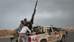 پس از آنکه نیروهای حامی قذافی مخالفان را از شهر بن جواد بیرون راندند، نیروهای شورشی برای خروج از شهر راس لانوف در مرکز لیبی در حال سوار شدن پشت یک وانت هستند. ۲۹ مارس ۲۰۱۱