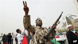 An armed Libyan rebel chant anti- Gadhafi slogans during a demonstration for students of the faculty of medicine of the University of Qar Younis, Benghazi, March 13, 2011