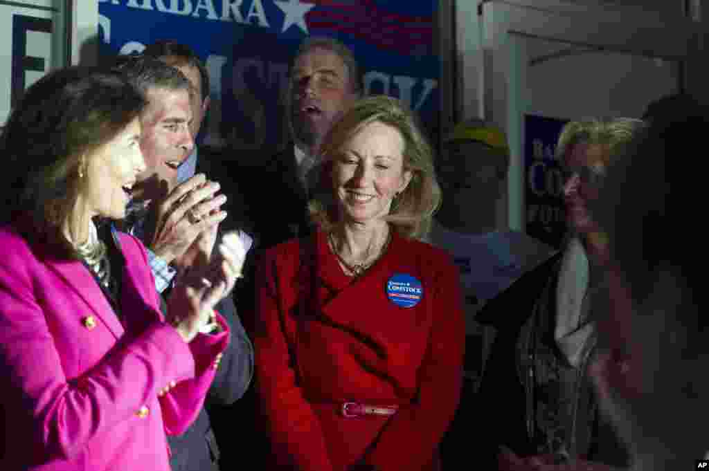 Candidate pour la Maison Blanche, Barbara Comstock, centre, est acclamée pendant qu&rsquo;elle est introduite pour&nbsp; un discours lors de la compagne appelant les électeurs au vote, le 3 novembre 2014. A gauche Susan Allen, épouse de l&rsquo;ancien gouverneur George Allen et à droite, Ann Romney, épouse du candidat Mitt Romney. (AP Photo/Cliff Owen) 