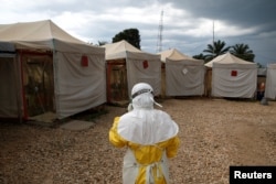 FILE PHOTO: A health worker wearing Ebola protection gear, prepares to enter the Biosecure Emergency Care Unit at the Alliance for International Medical Action ebola treatment center in Beni, DRC, March 30, 2019.