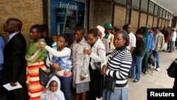 Warga harus antri panjang untung mengambil uang tunai dari ATM sebuah Bank di Harare, Zimbabwe, Selasa (28/11).