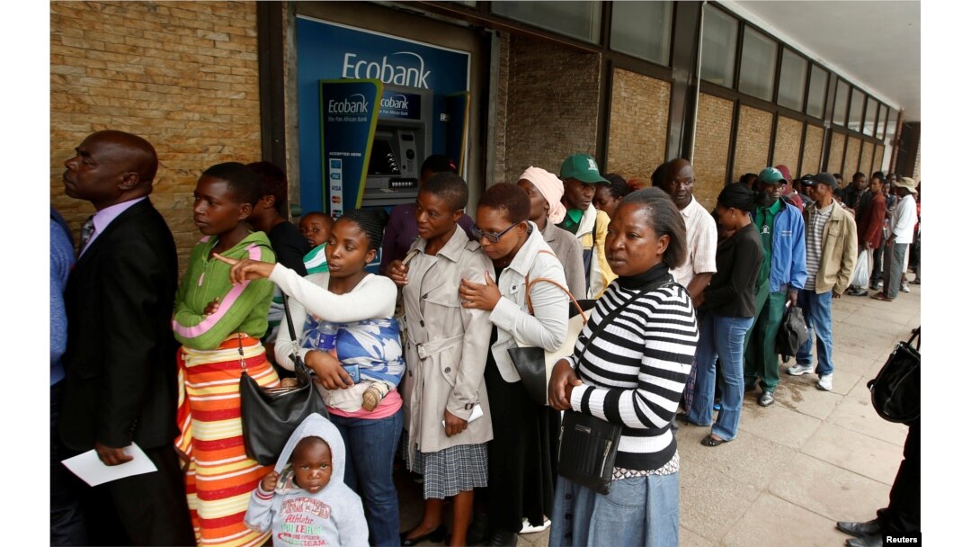 People queue to withdraw cash outside a bank in Harare, Zimbabwe, Nov. 28, 2017.