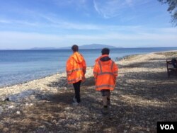 Volunteers from Swiss Cross, an aid organization for refugees in Greece, scan the sea, waiting to help new arrivals in Lesbos, April 1, 2016. (H. Murdock/VOA)