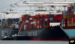 The Yang Ming shipping line container ship Ym Utmost is unloaded at the Port of Oakland on Monday, July 2, 2018, in Oakland, Calif. The Trump administration on Friday, July 6, 2018, will start imposing tariffs on $34 billion in Chinese imports.