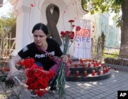 A woman lays flowers at the memorial monument dedicated to AIDS victims to mark the World Memory Day of people who died of AIDS in Kiev, Ukraine, May 19, 2017.