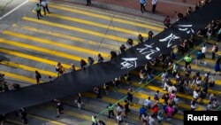 Demonstran gerakan Occupy Central berjalan membawa kain hitam sepanjang 500 meter di Hong Kong (14/9). (Reuters/Tyrone Siu)