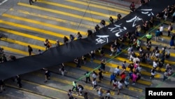 Occupy Central protesters march with 500-meter long black cloth, which they say symbolizes the loss of credibility in Beijing's refusal to allow true democracy in Hong Kong, Sept. 14, 2014.