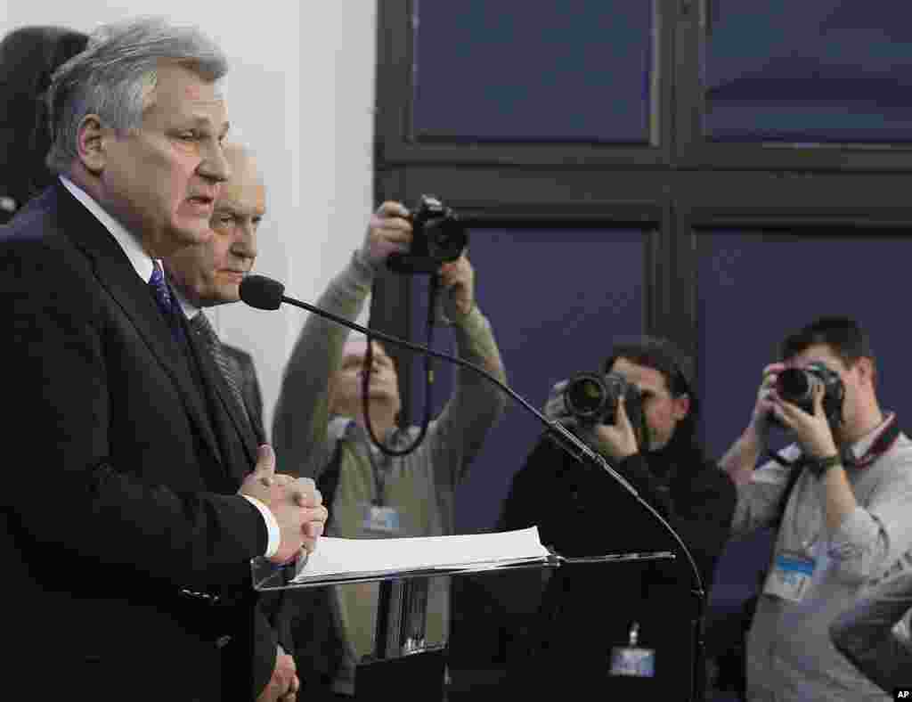 Former Polish President Aleskander Kwasniewski, left, and former Prime Minister Leszek Miller, second left, who were in power when the CIA ran a secret prison in Poland, speak to reporters in Warsaw about a report on CIA techniques, Dec. 10, 2014.