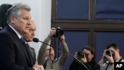 Cựu Tổng thống Ba Lan Aleksander Kwasniewski, trái, và cựu Thủ tướng Leszek Miller, thứ hai từ trái sang, trả lời báo giới ở Warsaw về bản phúc trình công bố hình thức CIA điều tra các nghi can khủng bố 10/12/2014.