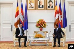 FILE- Hungarian Foreign Minister Peter Szijjarto, left, talks with Cambodian Prime Minister Hun Sen during a meeting at Peace Palace in Phnom Penh, Cambodia, Tuesday, Nov. 3, 2020. (AP Photo)