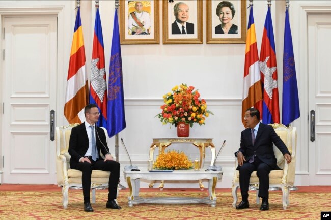 FILE- Hungarian Foreign Minister Peter Szijjarto, left, talks with Cambodian Prime Minister Hun Sen during a meeting at Peace Palace in Phnom Penh, Cambodia, Tuesday, Nov. 3, 2020. (AP Photo)