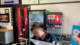 Valentina Muro rings up a customer at the Broadway Café in Van Horn, Texas, on Sunday, July 18, 2021. (AP Photo/Sean Murphy)