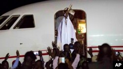 Gambia's defeated leader Yahya Jammeh waves to supporters as he departs from Banjul airport, Jan. 21, 2017. Jammeh announced he has decided to relinquish power, after hours of last-ditch talks with regional leaders and the threat by a regional military force to make him leave.