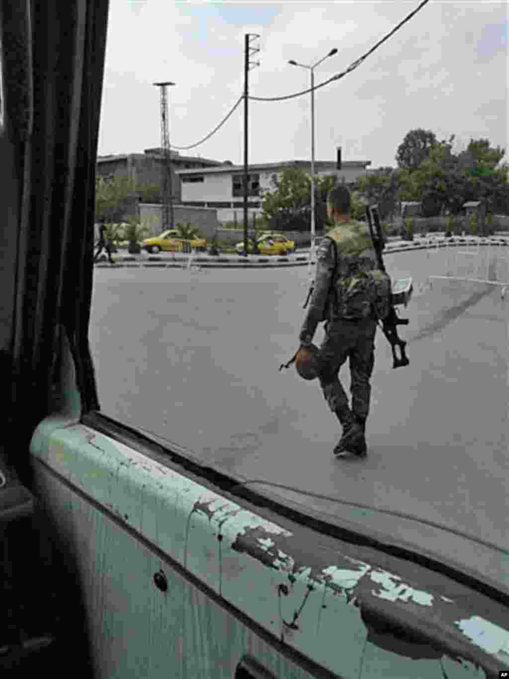In this image taken on a mobile phone, a Syrian soldier patrols streets in Damascus, Syria, May 8, 2011. (AP image)