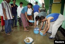 Anggota GAM yang dipenjara mengambil makan siang mereka untuk dimakan di sel isolasi mereka di penjara Sukamiskin di Bandung, 2005. (Foto: Reuters)