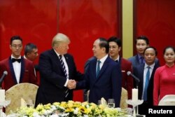Vietnam's President Tran Dai Quang welcomes U.S. President Donald Trump with a state banquet at the International Convention Center in Hanoi, Nov. 11, 2017.
