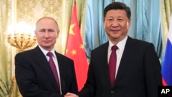 FILE - Russian President Vladimir Putin, left, shakes hands with Chinese President Xi Jinping during a meeting in the Kremlin, in Moscow, Russia, July 4, 2017.