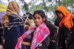 Seorang gadis pengungsi Rohingya terdampar di pantai Kuala Simpang Ulim, Aceh Timur, Provinsi Aceh, setelah berlayar lebih dari 100 hari, 4 Juni 2021. (Antara Foto/Hayaturrahmah/via Reuters)