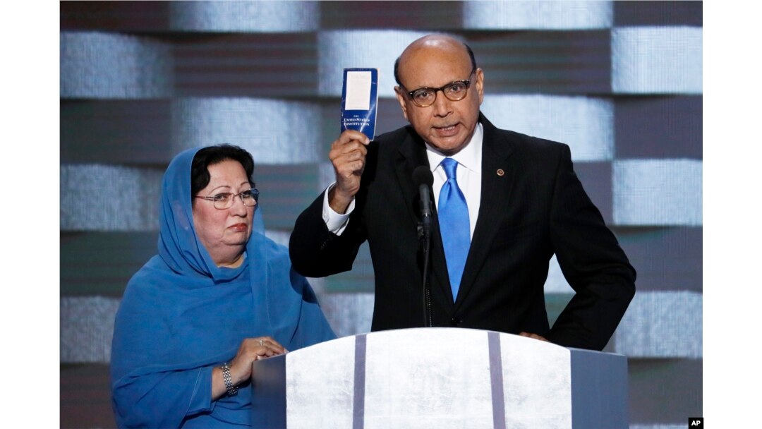 FILE - Khizr Khan, father of fallen U.S. Army Capt. Humayun S. M. Khan, holds up a copy of the Constitution of the United States as his wife, Ghazala, listens during the final day of the Democratic National Convention in Philadelphia , July 28, 2016.