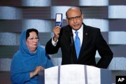 FILE - Khizr Khan, father of fallen U.S. Army Capt. Humayun S. M. Khan, holds up a copy of the Constitution of the United States as his wife, Ghazala, listens during the final day of the Democratic National Convention in Philadelphia , July 28, 2016.