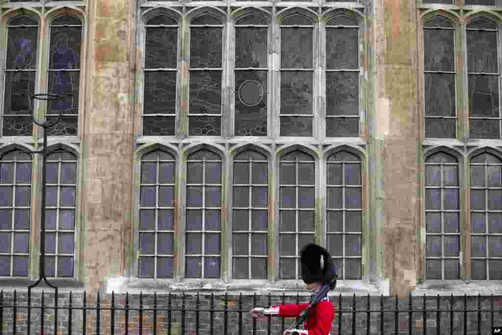 A Grenadier Guard marches past the stained glass windows of the Chapel Royal outside St. James's Palace, in London, Oct. 23, 2013.