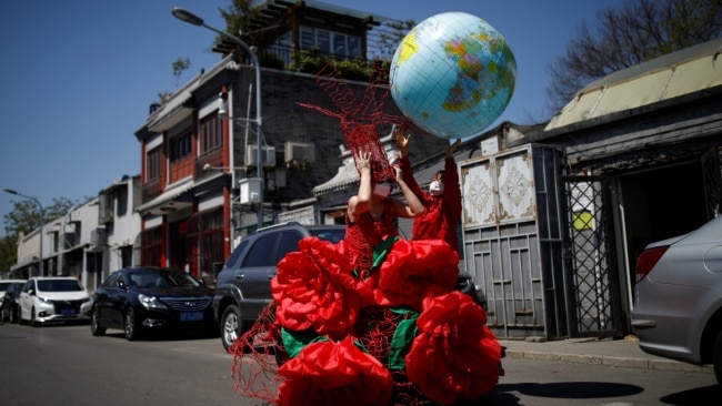 一名艺术家在北京的蓝天下庆祝“地球日”。(2020年4月22日)