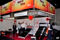FILE - People visit China's booth at a solar exhibit in Johannesburg, South Africa, March 2, 2011.