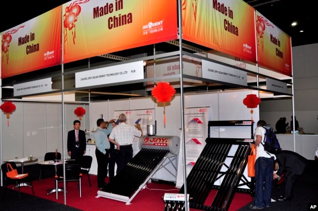 FILE - People visit China's booth at a solar exhibit in Johannesburg, South Africa, March 2, 2011.
