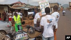 Health workers speak to people on the streets to educate them about the deadly Ebola virus in the city of Freetown, Sierra Leone, Aug. 4, 2014.