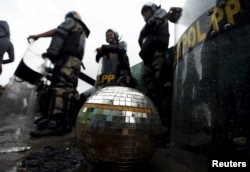 FILE - A disco ball rests near civil service police unit members as buildings are demolished at Kalijodo red light district in Jakarta, Indonesia, Feb. 29, 2016.
