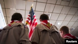 FILE - Boy Scouts stand on stage with a U.S. flag during the Pledge of Allegiance at the outset of a politics summit in Manchester, New Hampshire, April 12, 2014. 