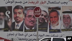 A car passes a pro-government billboard in Muharraq, Bahrain, with pictures of jailed Bahraini Shiite and Sunni opposition leaders, May 8, 2011