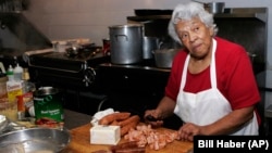 FILE - In this Jan. 20, 2009, file photo, Chef Leah Chase, owner of Dooky Chase' prepares for lunch at her restaurant in New Orleans. Chase was lovingly known as the "Queen of Creole Cuisine." (AP Photo/Bill Haber, File)