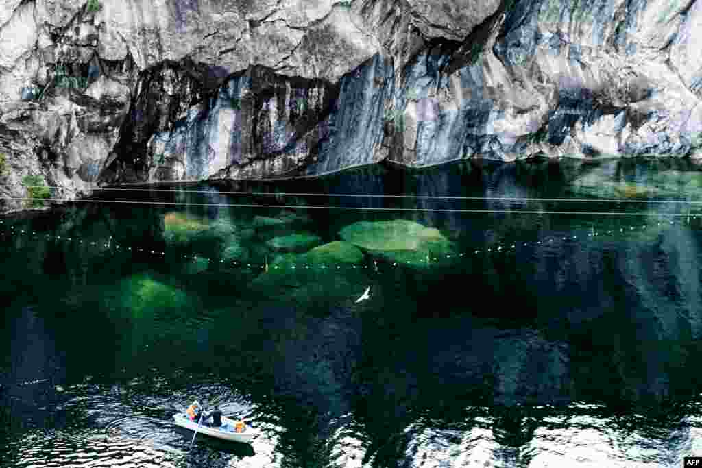 People sit in a boat floating in a marble quarry close to village of Ruskeala, republic of Karelia.