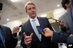 FILE - Sen. Jeff Flake speaks with reporters in Washington, Nov. 14, 2018.