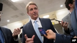 Sen. Jeff Flake speaks with reporters before he and Sen. Chris Coons try to bring up the legislation to protect special counsel Robert Mueller, at the Capitol in Washington, Nov. 14, 2018. 