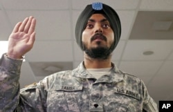 FILE - U.S. Army Spc. Simran Lamba takes the oath of citizenship to become a naturalized citizen before his graduation from basic training at Fort Jackson, South Carolina, Nov. 10, 2010. Updated Pentagon guidelines now make it harder for foreign-born military recruits to qualify for expedited U.S. naturalization.