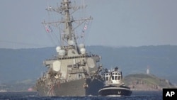 The damaged USS Fitzgerald is towed by a tugboat near the U.S. naval base in Yokosuka, southwest of Tokyo, after the destroyer collided with the Philippine-registered container ship ACX Crystal off the Izu Peninsula, June 17, 2017.