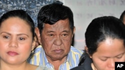 FILE – Powerful Filipino clan leader Andal Ampatuan Sr., center, is arraigned on electoral sabotage charges in 2012. A suspect in the 2009 massacre of at least 57 people, he died in July 2015.