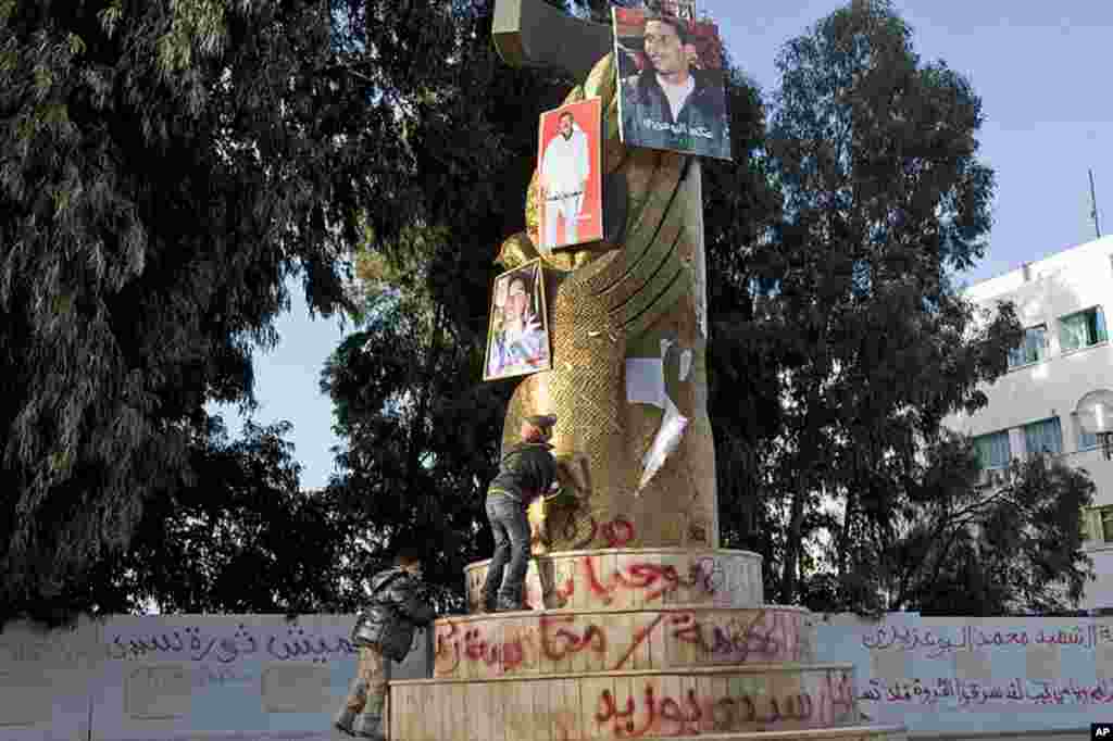 A picture of Mohamed Bouazizi, the local fruit vendor who set himself on fire Dec. 17, is seen on the top of a monument along with pictures of other victims killed in the clashes following his act, in the center of the town of Sidi Bouzid, Tunisia, March 