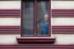 Starji stanovnik Beograda posmatra Povorku ponosa tokom Belgrej prajda, u Beogradu, 18. aprila 2021. (Foto: AP, Darko Vojinović)