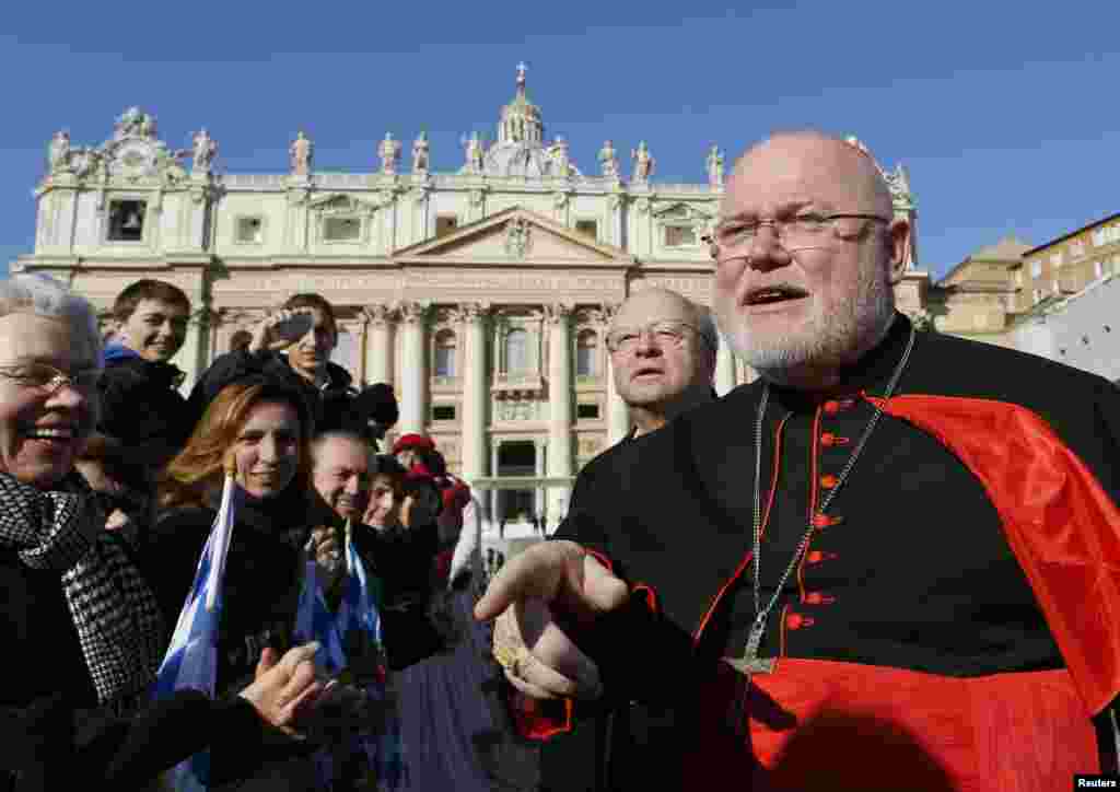 German Cardinal Reinhard Marx speaks with the faithful in a packed Saint Peter's Square where Pope Benedict XVI holds his last general audience, at the Vatican Feb. 27, 2013.