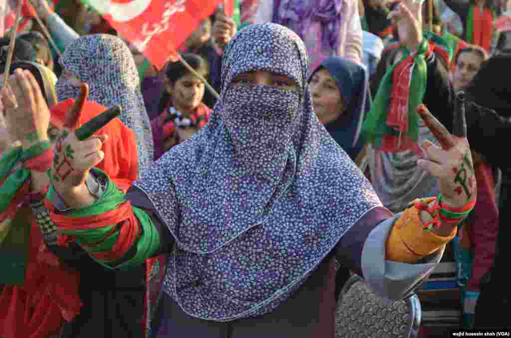 جناح ایونیو پر لگائے گئے سٹیج کے اردگرد خواتین نے اپنے چہروں پر عمران خان اور پارٹی کے جھنڈوں کی تصاویر بنوا رکھی تھی۔